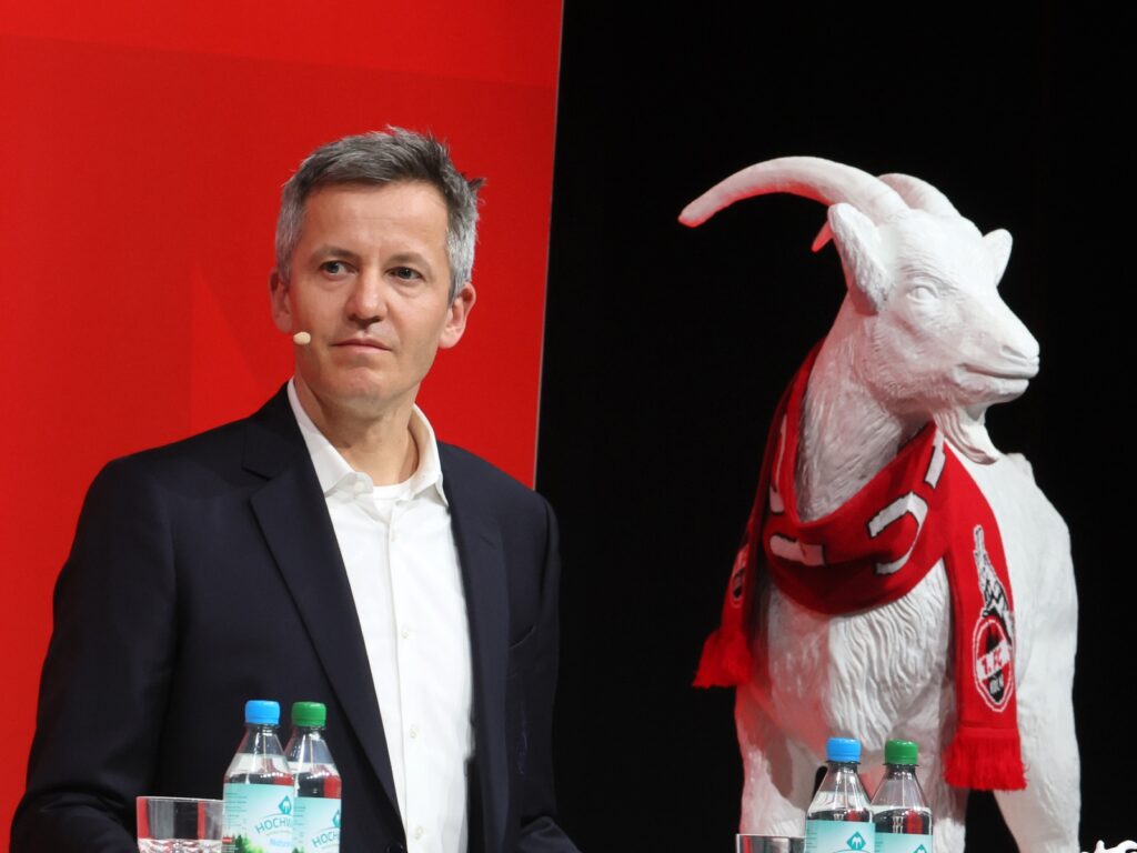 Philipp Türoff steht neben einer Hennes Figur.