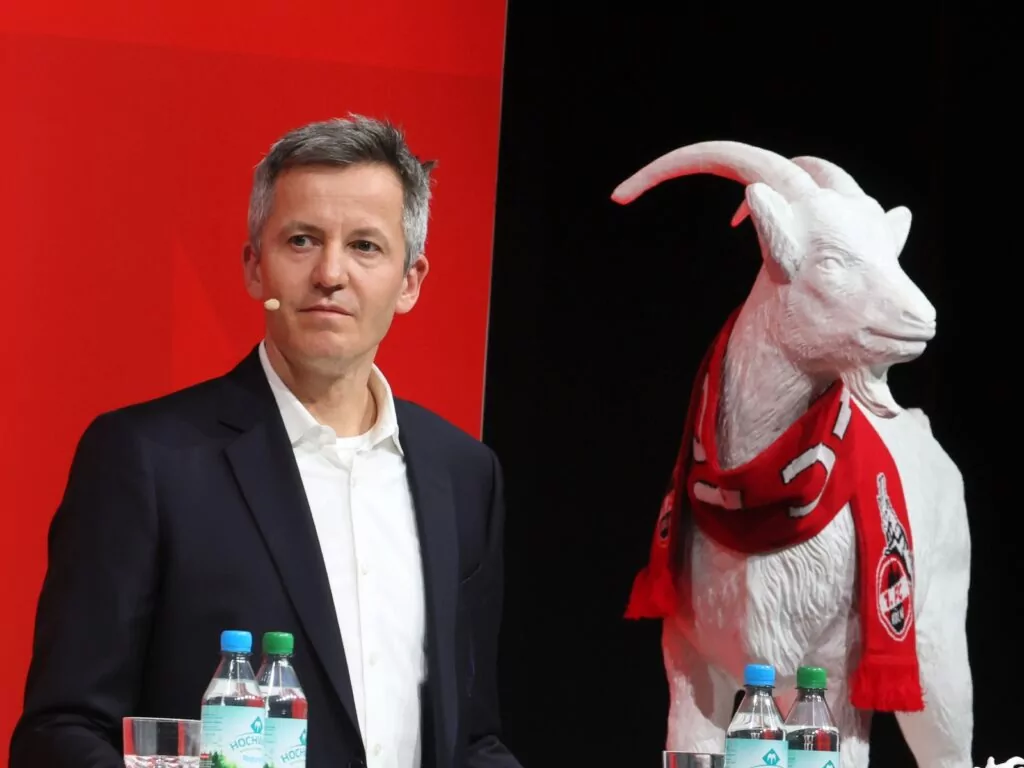 Philipp Türoff steht neben einer Hennes Figur.