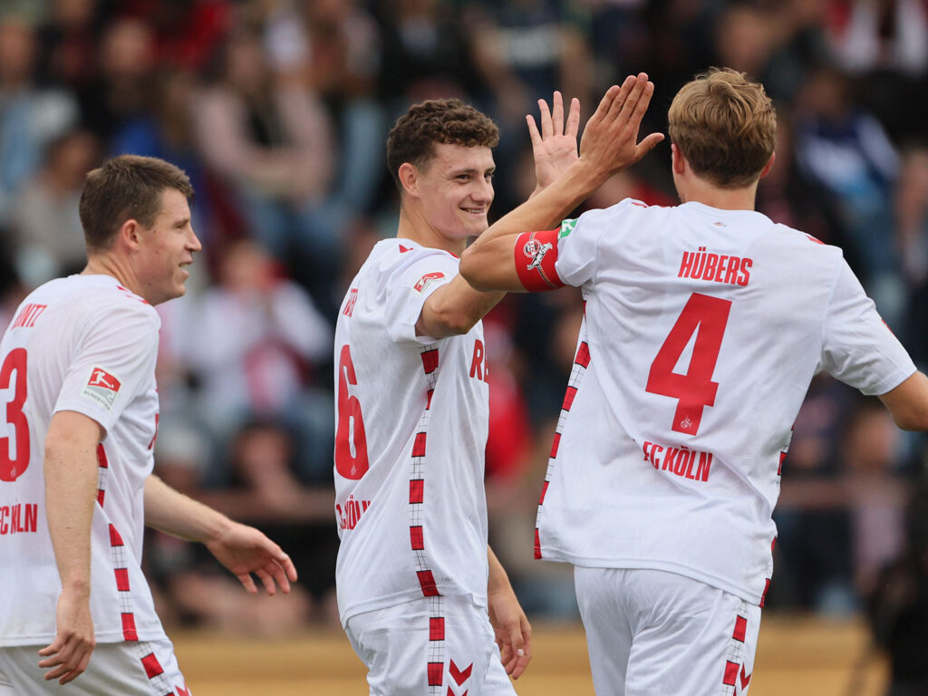 Eric Martel und Timo Hübers vom 1. FC Köln klatschen ab.