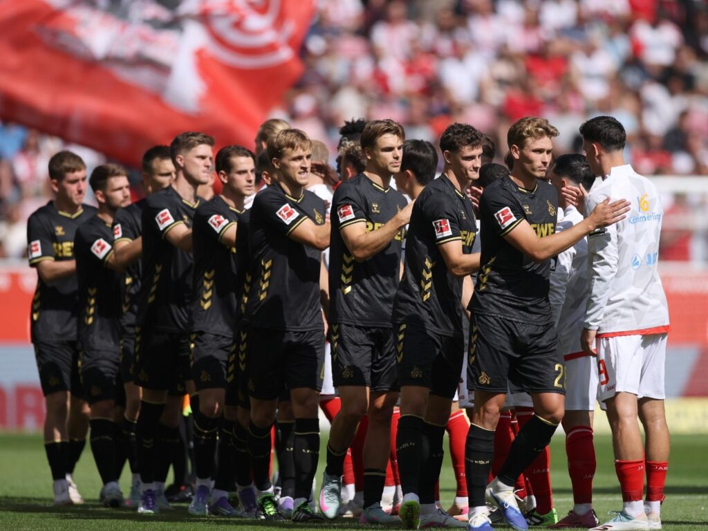 Die Kölner Spieler klatschen mit dem Gegner ab.